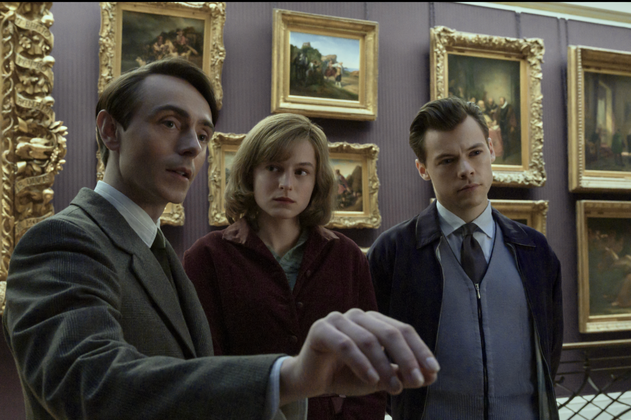The characters of My Policeman are featured in a museum, with plenty of pictures and frames behind them.